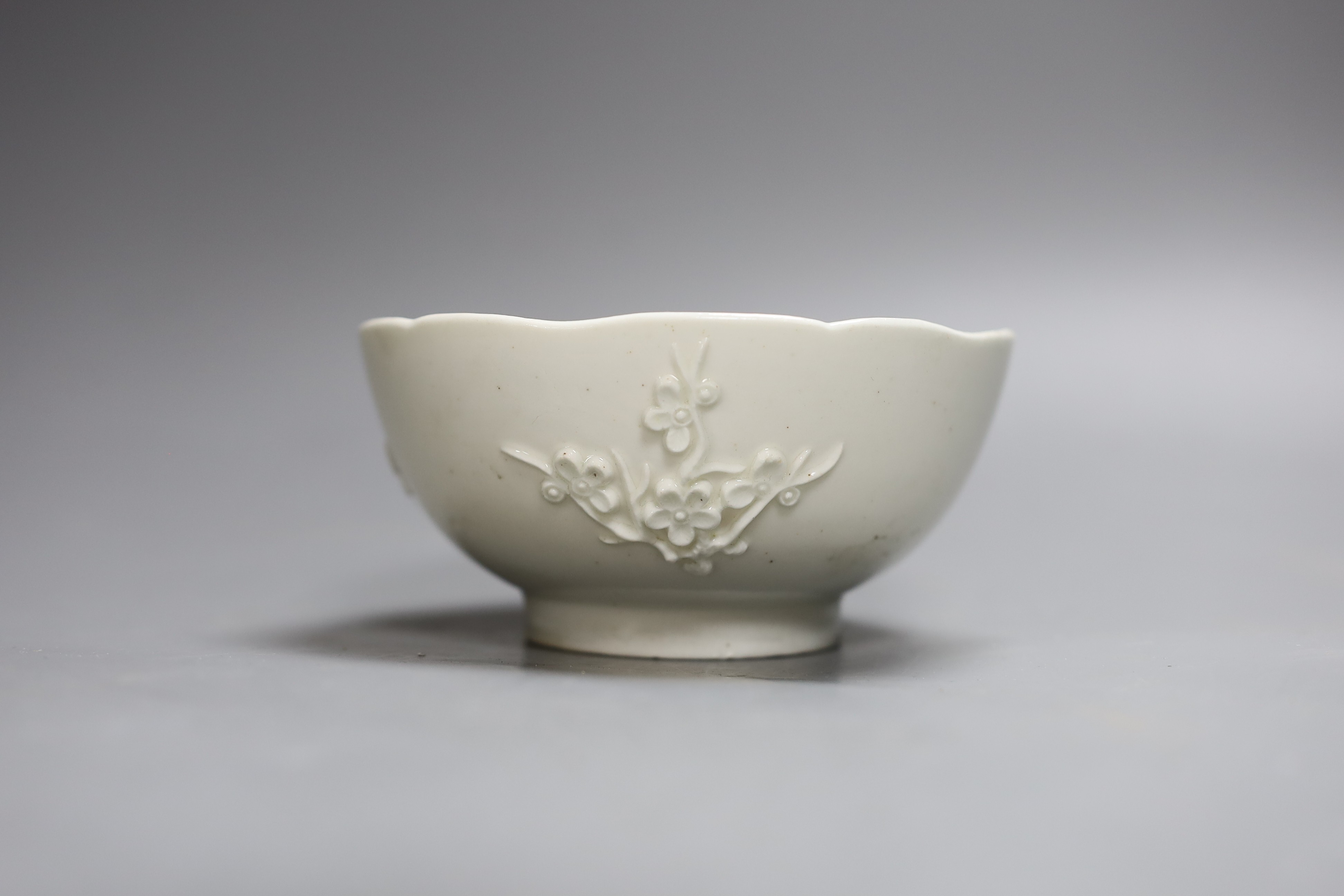 An 18th century Bow white glazed ‘prunus’ bowl, and a Bow octagonal plate, with floral design, 21cm diameter